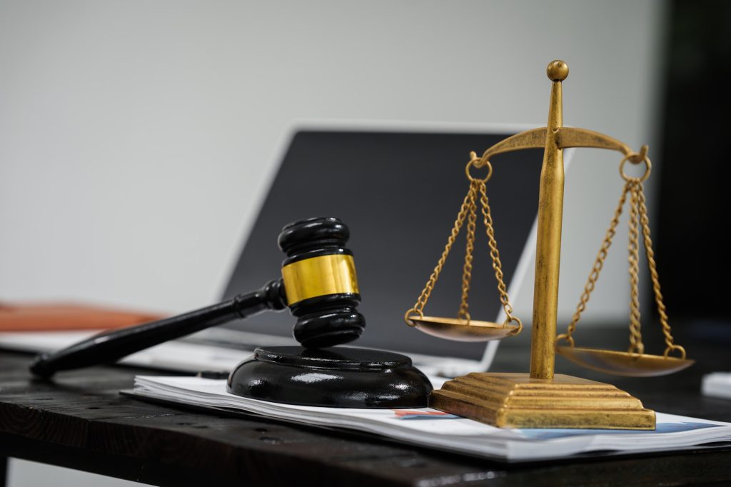 A lawyer's desk in an office,with legal documents, computers,and hammers placed neatly The setting