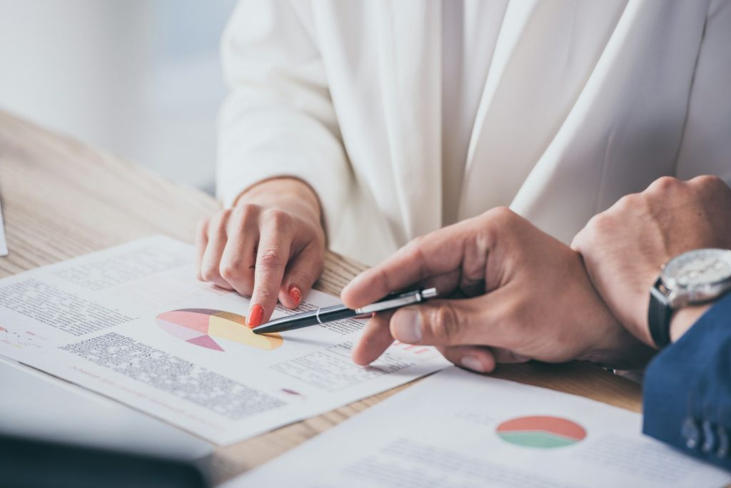 cropped view of two risk managers analyzing infographics together